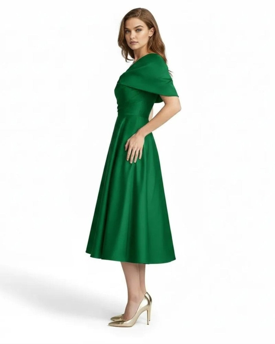 Side profile of woman wearing emerald green satin A-line formal wedding guest dress by Ondara.