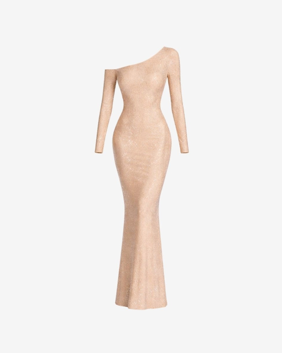 A long-sleeve, one-shoulder bodycon maxi dress in a shimmering champagne beige, shown on a plain light gray background.