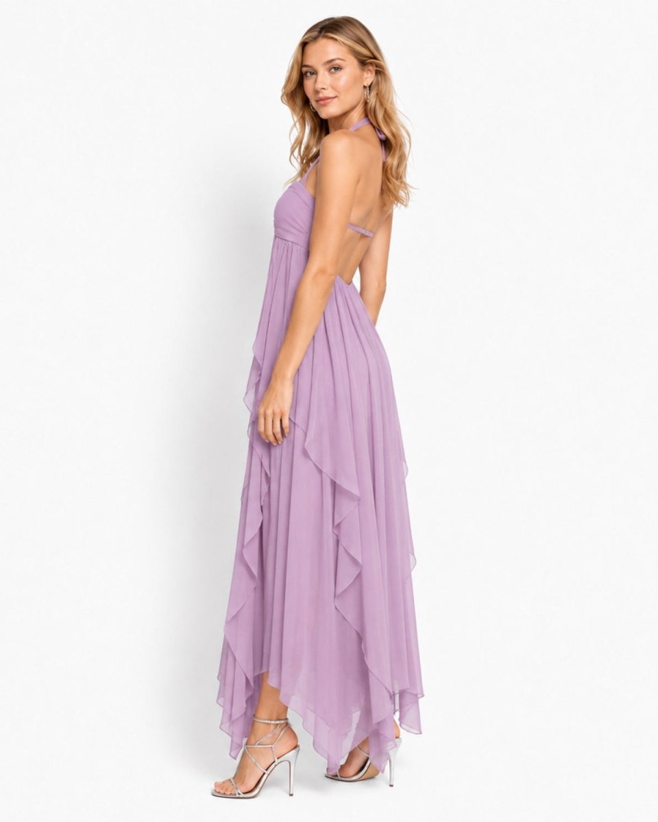 Side profile view of the Ondara purple Grecian maxi dress showing the open back design and handkerchief hem.