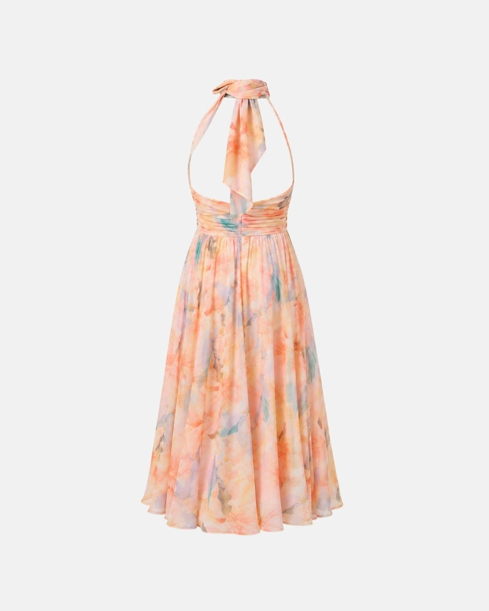 A halter-neck midi dress with a tie-front detail and a flowing skirt, featuring a soft watercolor tie-dye pattern in pastel orange, pink, and light blue on a light gray background.