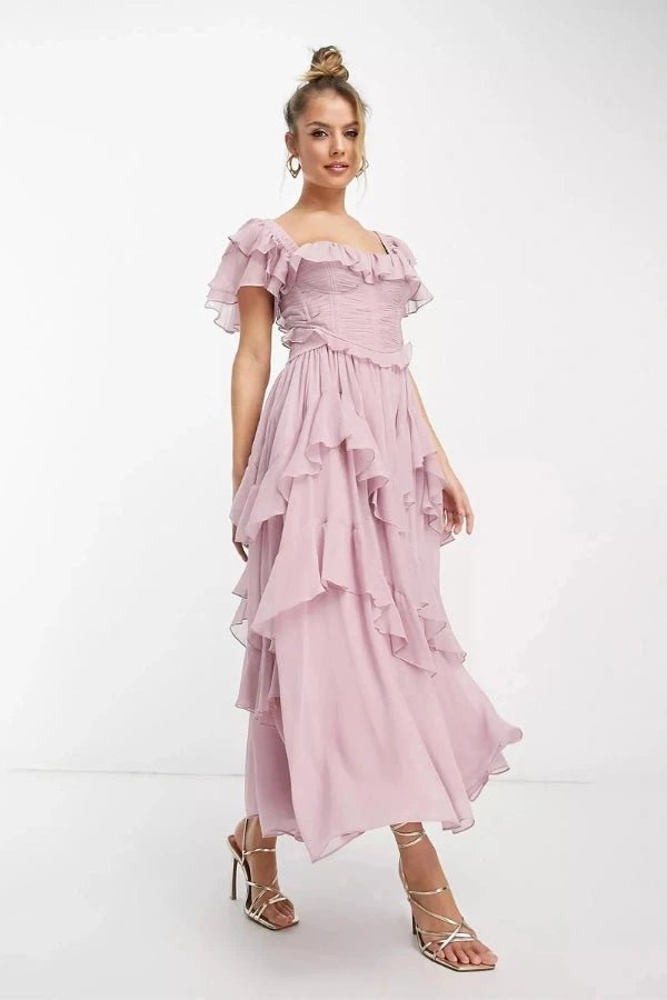 Angled side view showing the tiered chiffon skirt of the dusty pink formal co-ord dress set