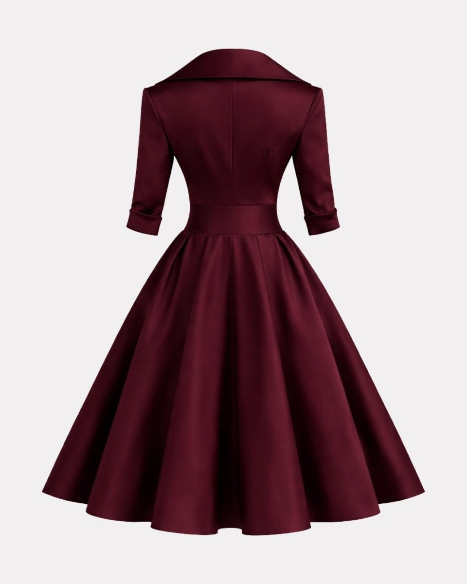 A dark burgundy satin dress with a structured collar, three-quarter sleeves, and a flared skirt, shown from the back against a light gray background.