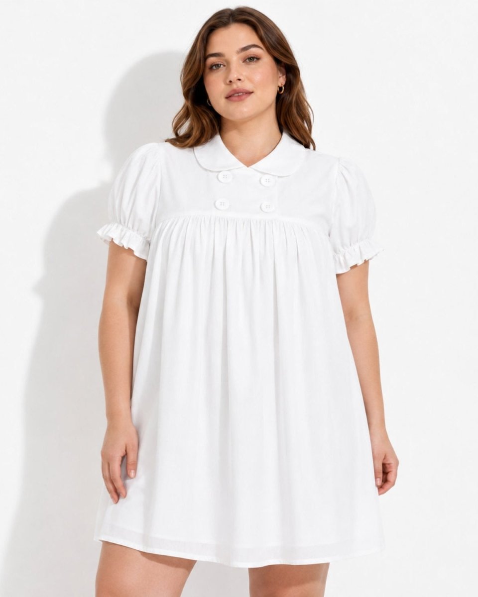 Curve model wearing an elegant white puff sleeve babydoll mini dress featuring an empire waist and Peter Pan collar by Ondara.