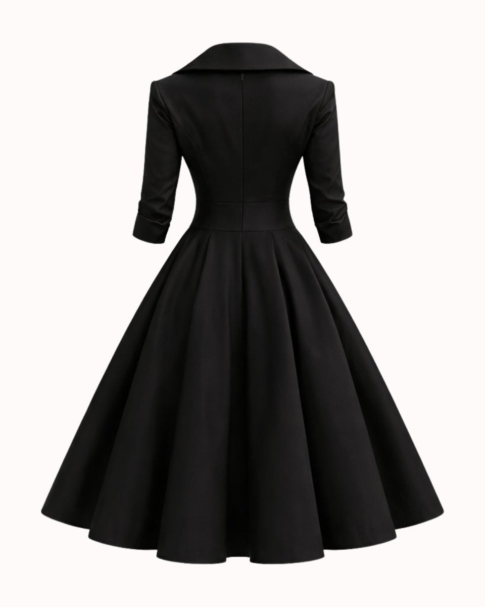 A black 1950s-style swing dress shown from the back, featuring a structured collar, three-quarter sleeves, a fitted waist, and a full flared skirt, set against a plain off-white background.