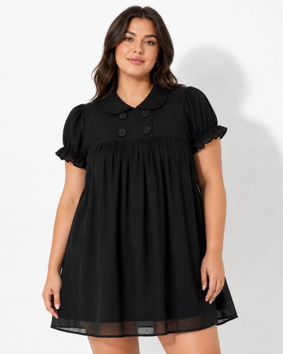 Brunette curve model wearing the Ondara black puff sleeve babydoll mini dress with tonal double-breasted buttons and ruffled cuffs.