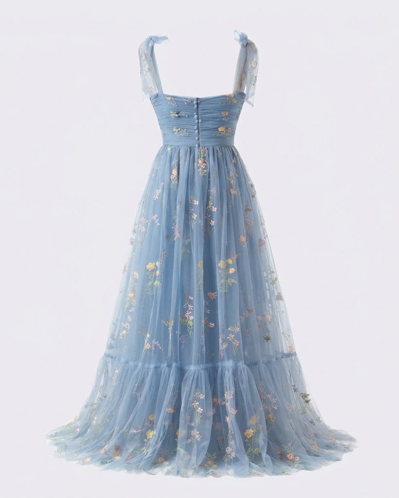 A light blue tulle midi dress with a sweetheart neckline, tie straps, a gathered corset-style bodice, and delicate floral embroidery, shown against a plain white background.