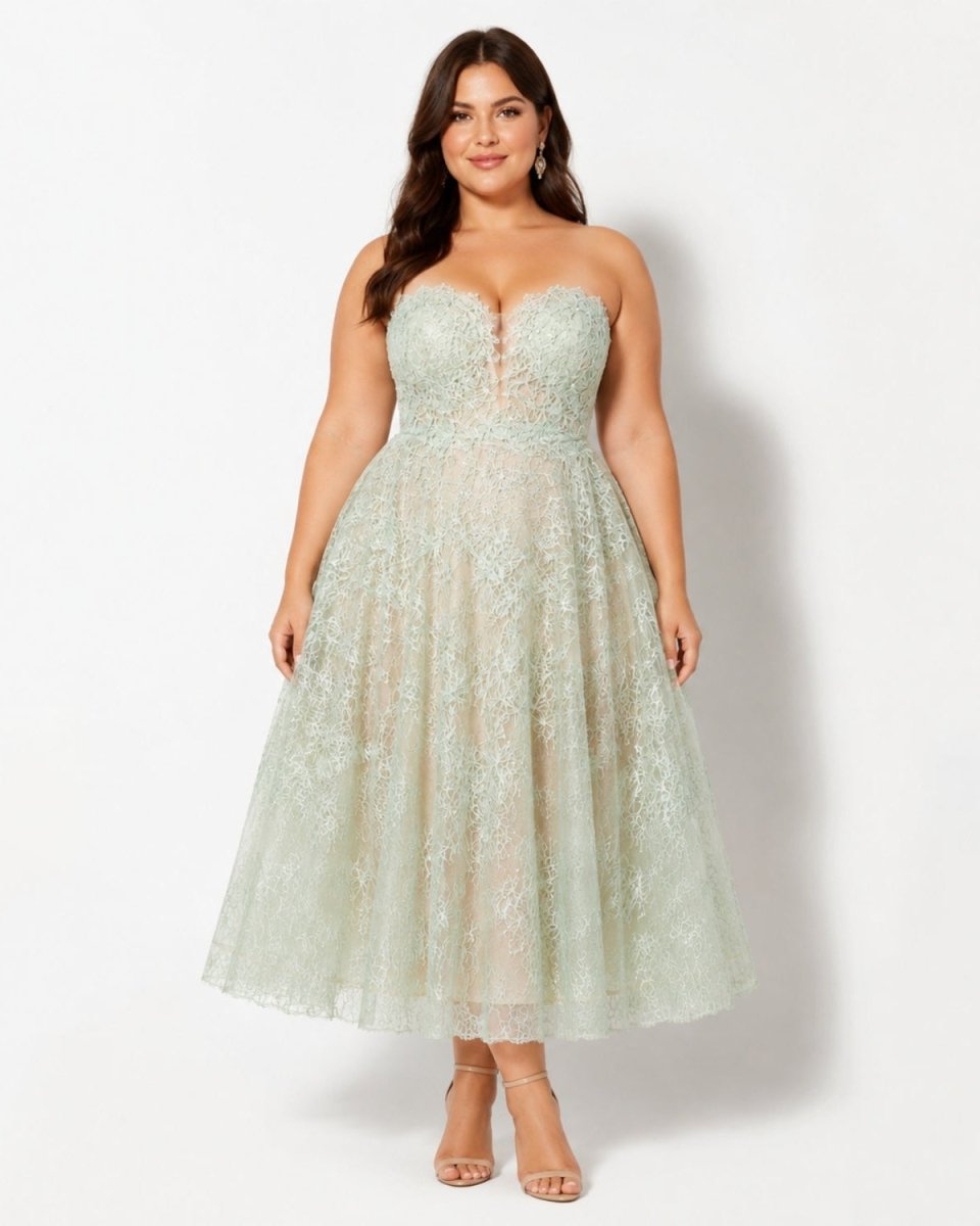 Plus size model beautifully showcasing the green strapless lace midi dress with an A-line tea-length skirt.