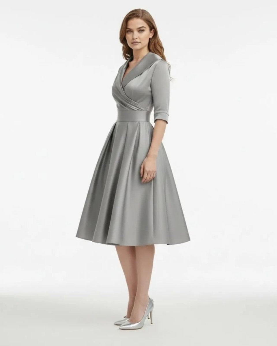 Woman wearing a gray dress with a white background