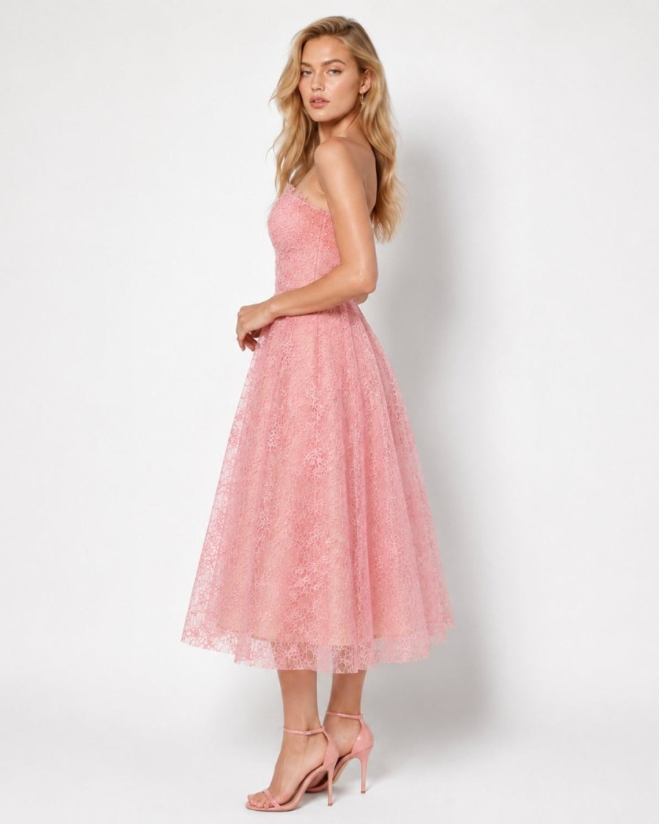 Back side profile of a blonde model wearing a pink formal lace midi dress showcasing the concealed back zipper.