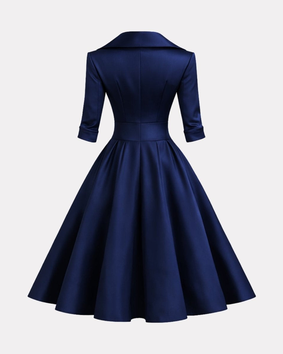 Navy blue dress with a fitted bodice and full skirt on a light gray background