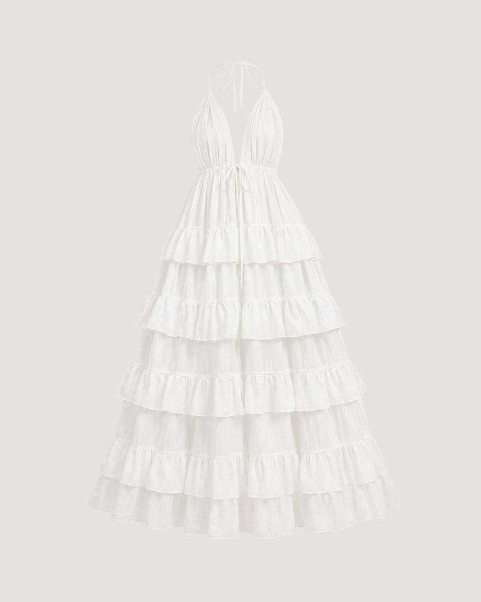 Studio flat lay of white luxury halter neck tiered maxi dress