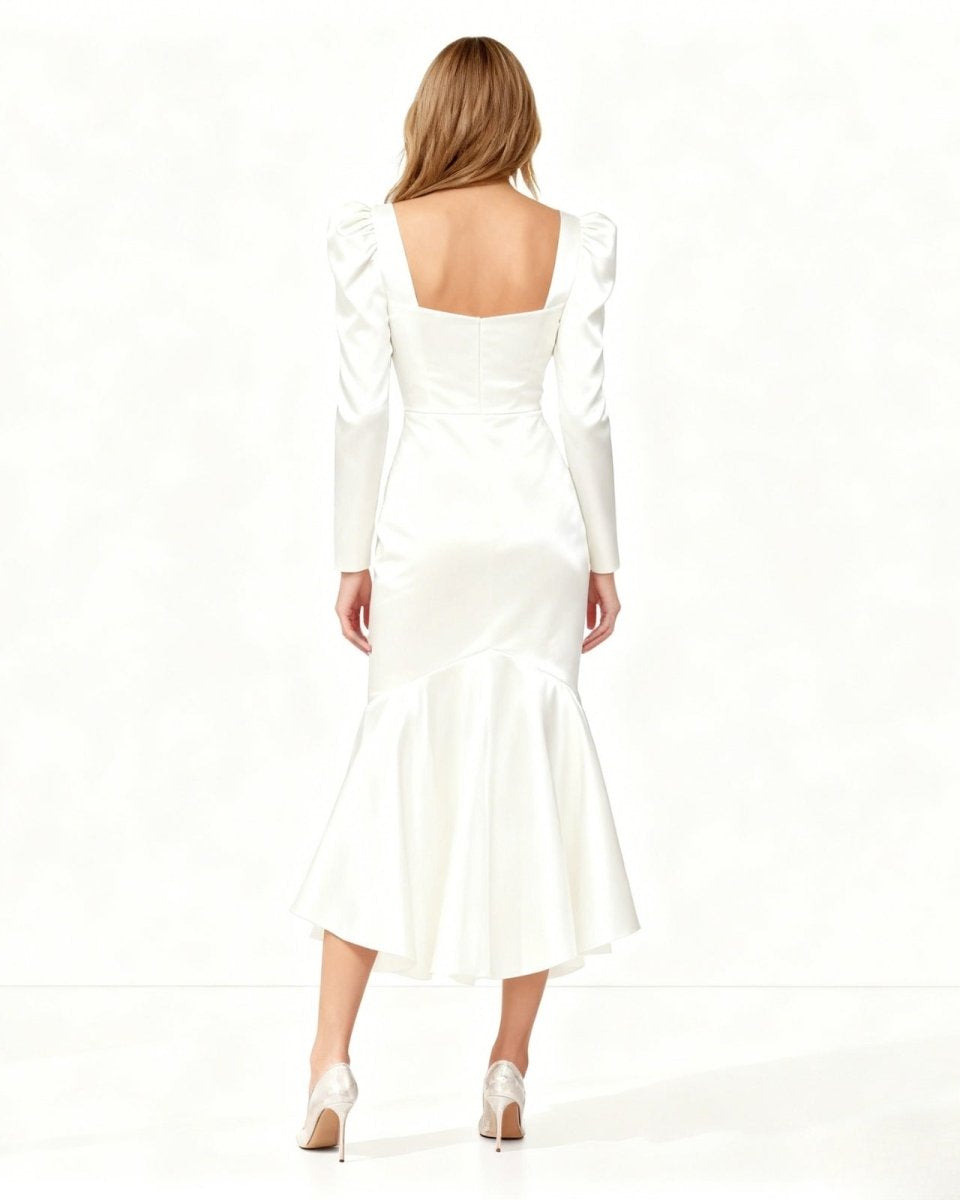 Woman wearing a white dress with long sleeves on a white background